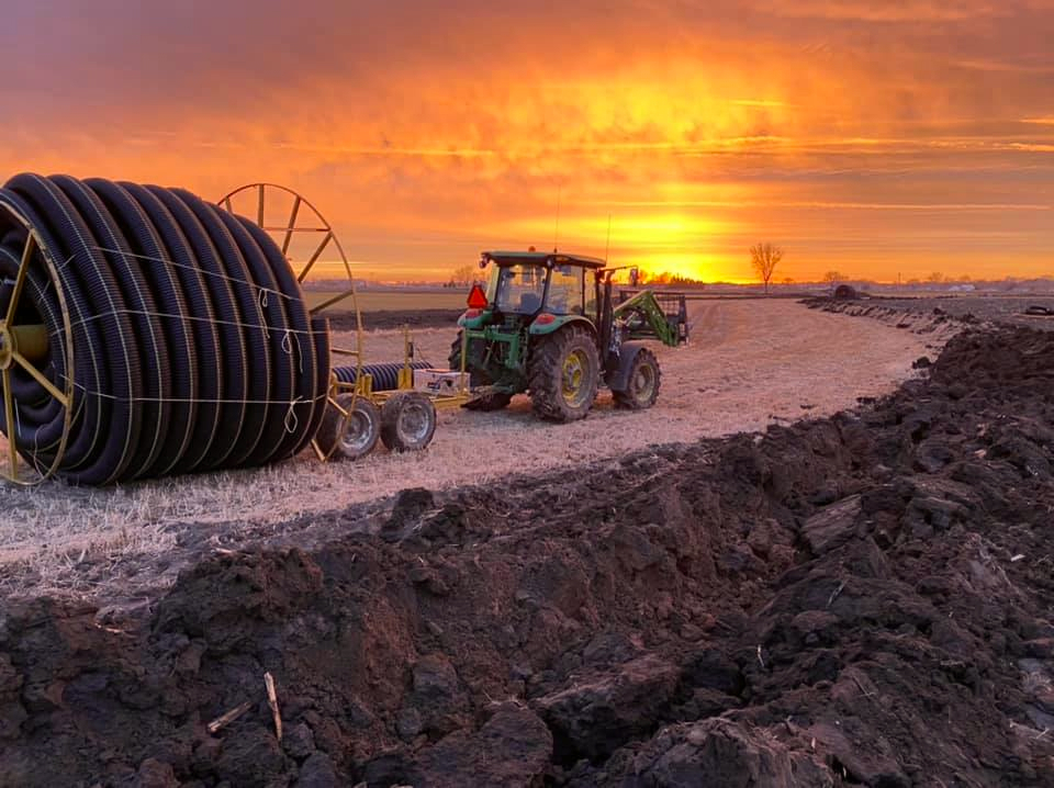 Tractor hauling drainage tiling